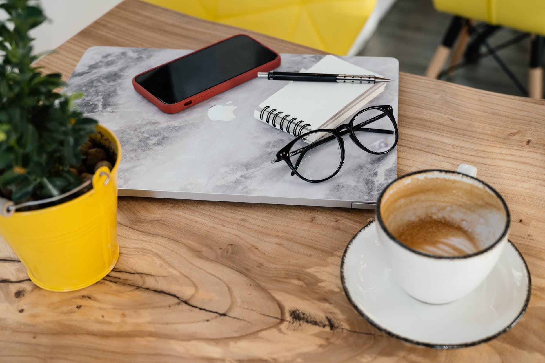 modern gadgets placed on table with cappuccino in cafeteria
